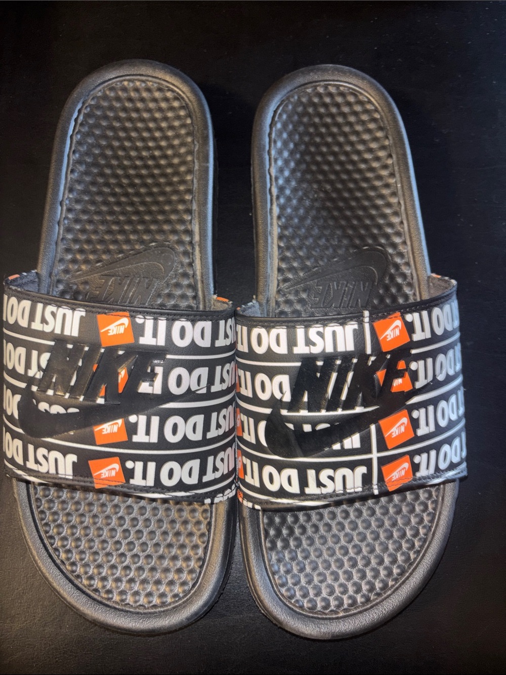 Nike Black Slide Sandals with White 'Just Do It' Graphic and Orange Accents